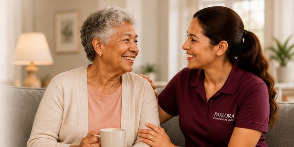 A Paxlora caregiver sharing coffee and conversation with an older woman